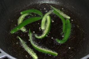 Green chilies getting roasted in edible oil